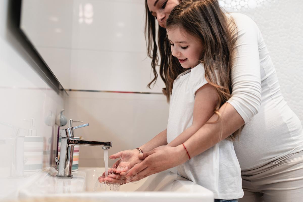 Pregnant Parent and Girl Handwashing